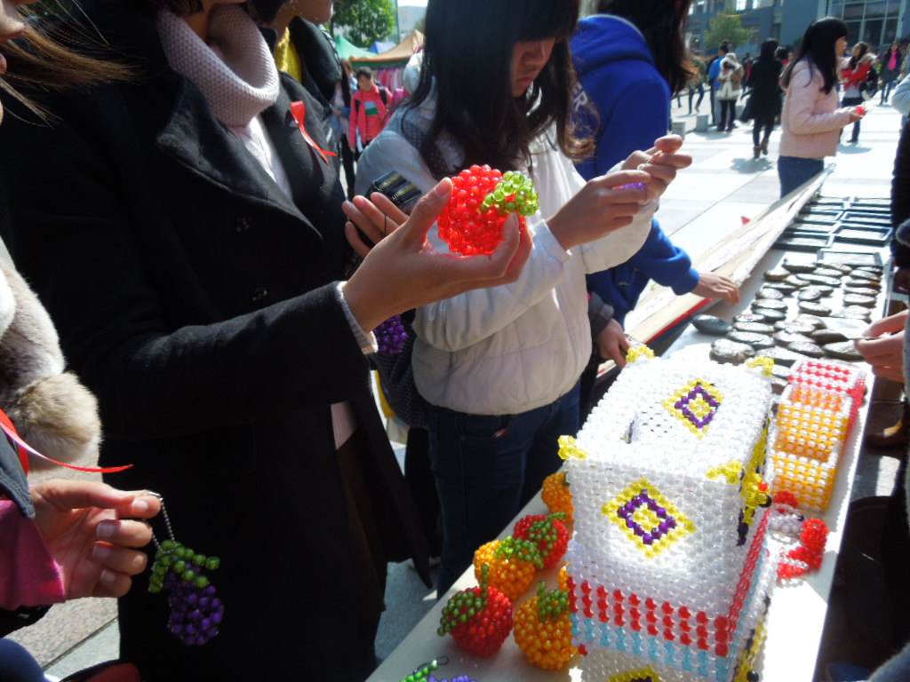 同学们在义卖桌前积极购买工艺品