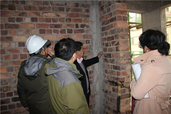 购房户代表在查看局部砂浆是否饱满（李华铭摄）