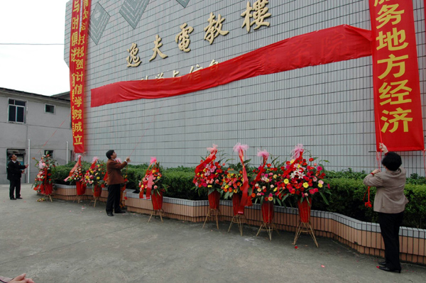 梁宏（中）、林观华和计信学院负责人一起揭下了学院牌匾上的红绸带。