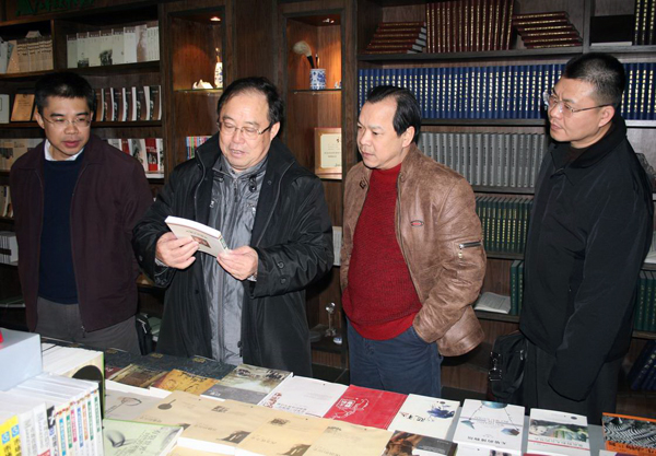 何利顺副厅长（左二）兴趣浓厚地参观了出版社展厅。