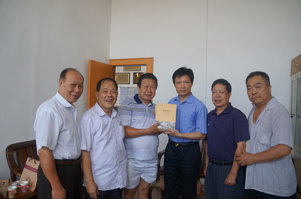 档案馆负责人向客人们赠送《图映岁月》一书