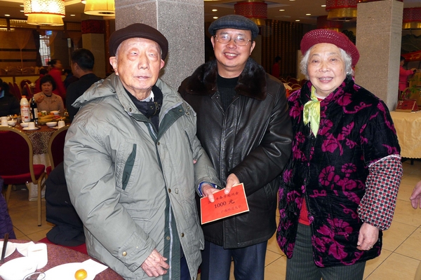 蔡昌卓副校长（中）为我校离休干部发放慰问金