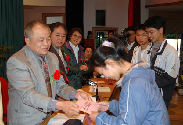 王冠川先生向受助学生发放助学金。