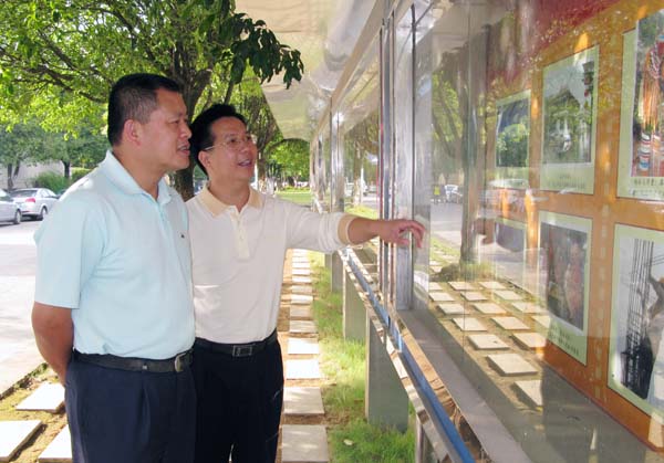 校党委副书记王源平(左)参观了摄影展。