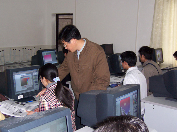 教师在指导学员制作Photoshop作品。