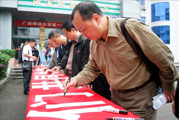 白晓军副校长在倡导节能减排的横幅上签名