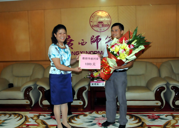 桂林市市委常委、副市长、宣传部部长陈丽华向我校教师代表陈振锋教授赠送献花和慰问金