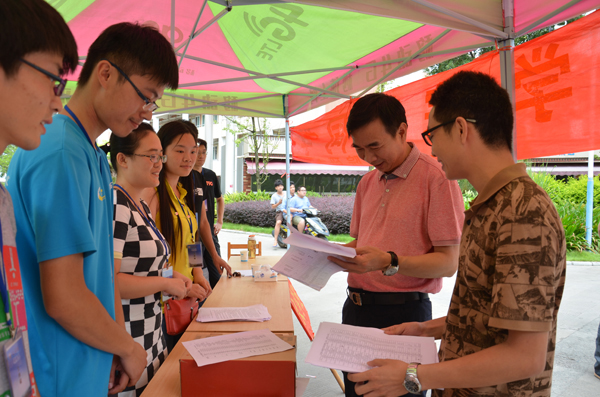 梁宏校长正在翻阅新生报到资料
