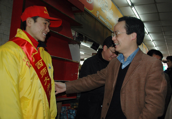 团区委副书记罗日新（右）在汽车站亲切看望慰问我校志愿者。