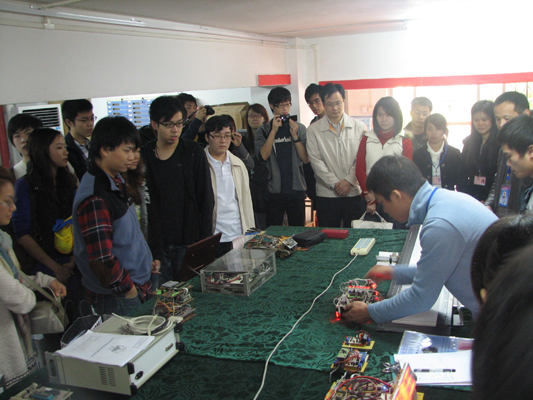 图为创新基地同学向香港理工大学电子及资讯工程学系来访师生展示作品