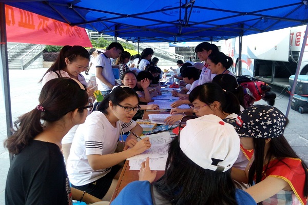 志愿者指导献血者填写登记表