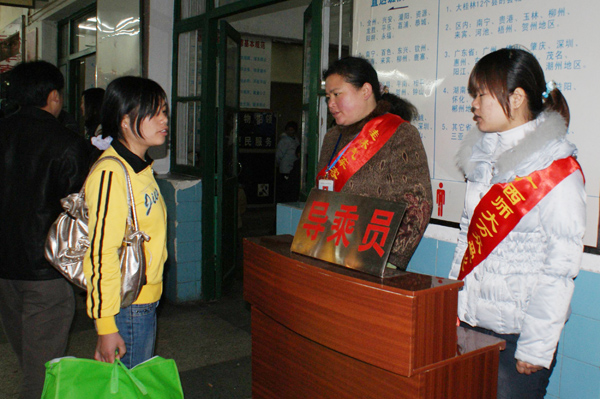 我校志愿者在汽车站充当导乘员。