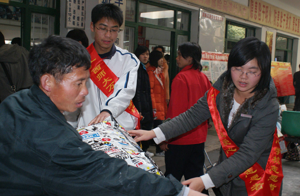 我校志愿者为乘客提行李。