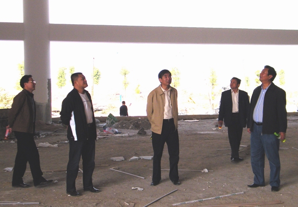 校领导和有关部门负责人在施工现场查看施工进展