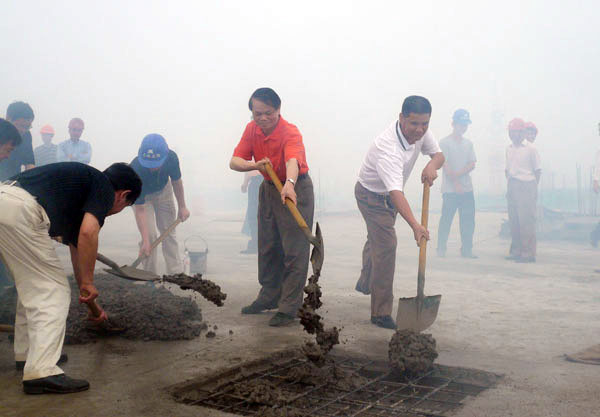 领导和嘉宾为大楼培土封顶。