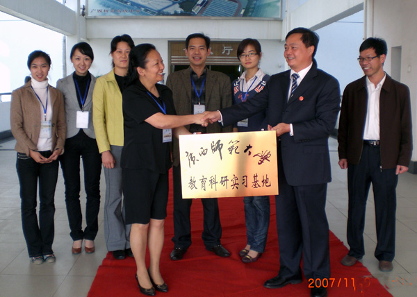 柳州高中校长李昌林（前排右）接受王枬书记授予的牌匾。