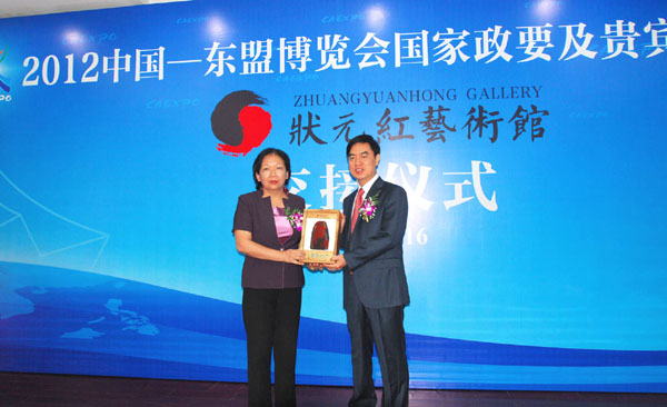 校党委书记王枬与博览会秘书处秘书长郑军健进行纪念品交接