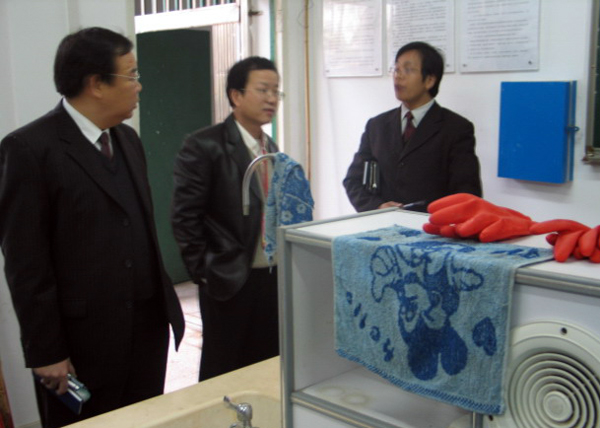 崔建国教授（中）参观化学化工学院实验室。