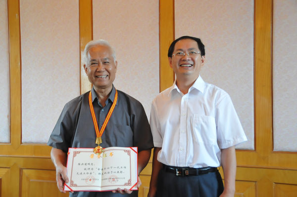 校党委副书记、学校关工委主任唐仁郭同志(右)代表上级关工委给陈兴道同志颁发荣誉奖章和证书