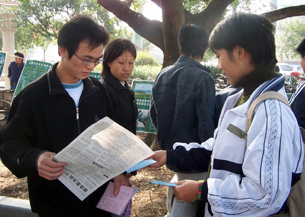 我校学生在给过路的市民们发放免费的 法制宣传资料。