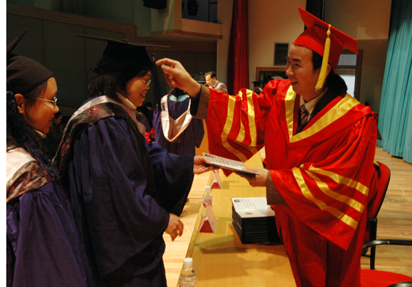 校长梁宏为学生颁发学位证书