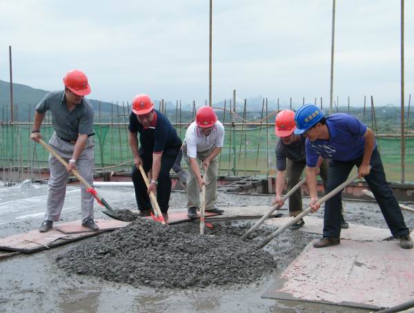 陈洪江副校长（左二）与承建单位领导共同为大楼培土封顶
