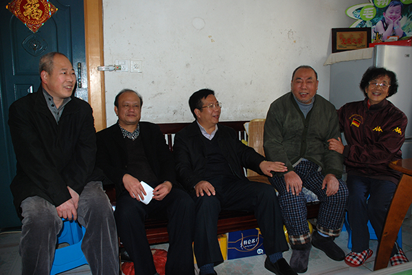 覃卫国副校长（中）在退休困难职工家慰问