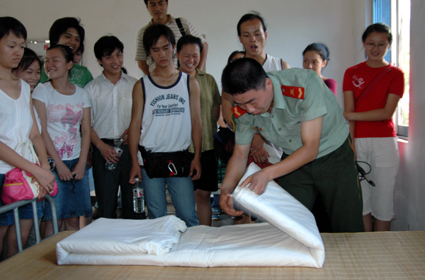 武警战士在表演叠被子。