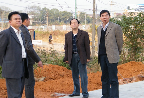 梁宏校长（右一）在二期学生公寓检查安保设施安装