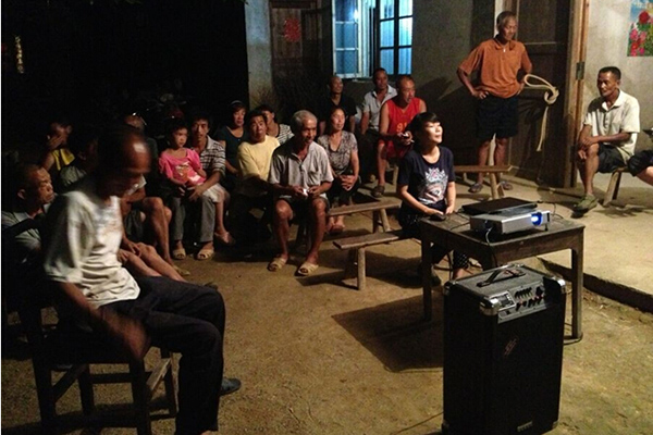 村民们围坐一堂观看视频