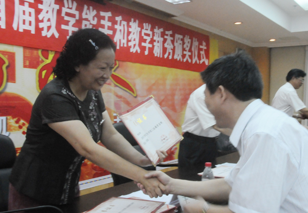 校党委书记王枬教授为获得教学名师的教授颁发证书。