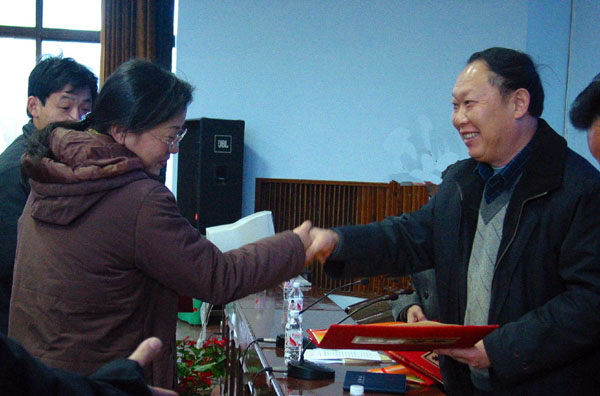 刘健斌(右)为获得先进的单位和个人颁奖。