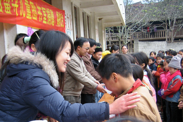 勉励贫困留守儿童好好读书。