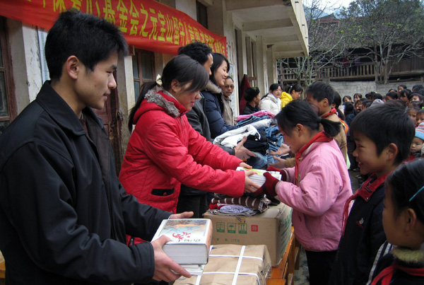 向贫困留守儿童捐赠书籍和衣物。