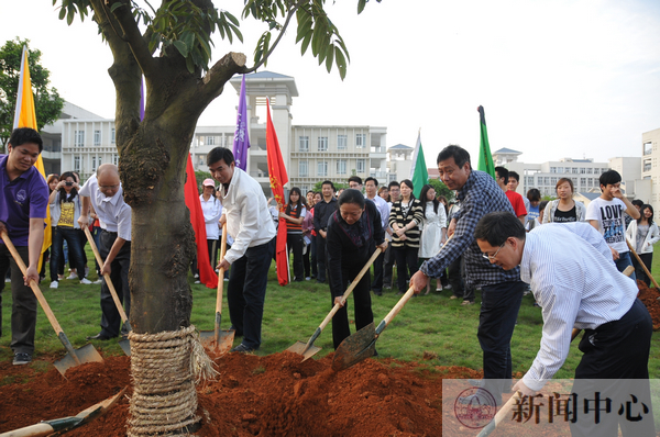 校领导与同学们共同种下一株红豆树