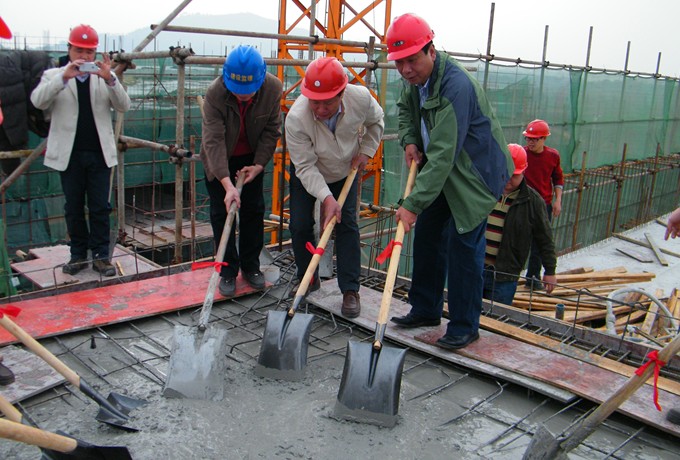 副校长陈洪江（右一）与承建单位领导共同为大楼培土封顶