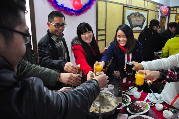 同学们在饭桌上举杯贺岁，开怀畅谈