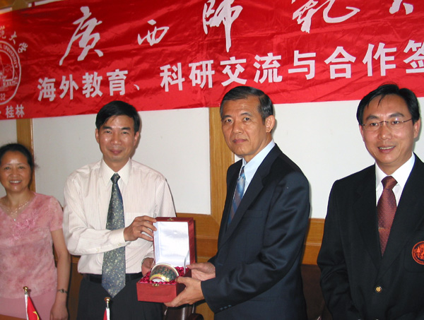 图为我校梁宏校长（左二）代表学校接受泰国拉克拉邦皇家工学院PrakitTangtisanon校长（右二）赠予的纪念品。