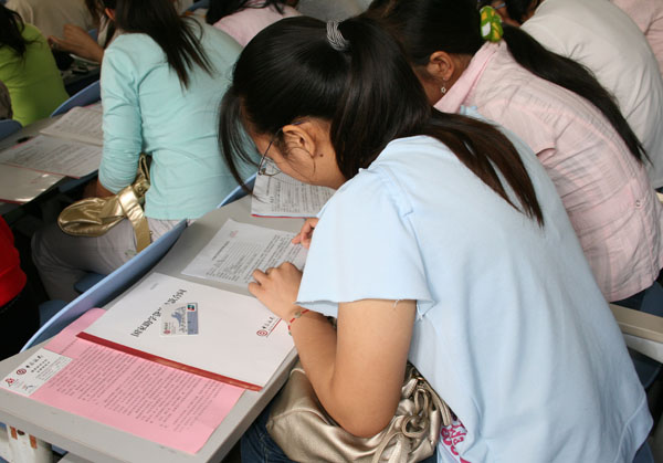 贷款的毕业生们现场填写还款协议。