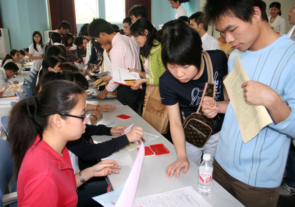 贷款的毕业生们与银行签订还款协议。