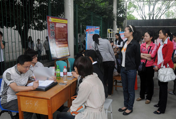女生们在摊求职点前应聘。