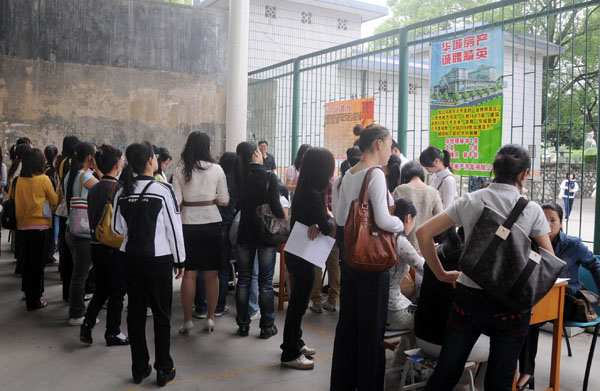 女生们在摊点前应聘。