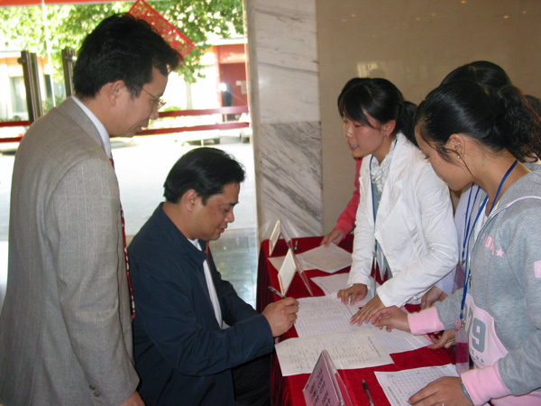 志愿者们热情接待回校报到的校友。