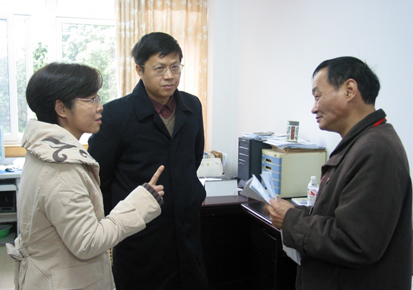 吴晓鸣研究员（右一）在物电学院资料室考察时询问情况。