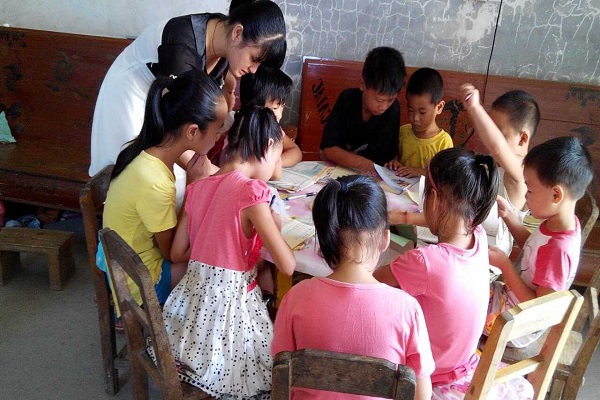 志愿者陈荣芳在耐心地给学生辅导学习