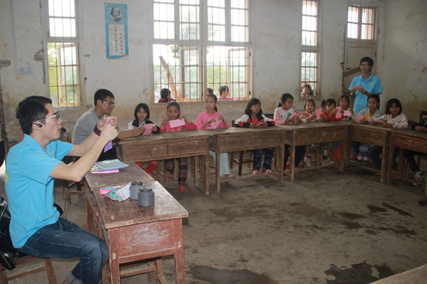 支教团成员彭琛为同学们讲解百合花的折法（周晟旻/摄）