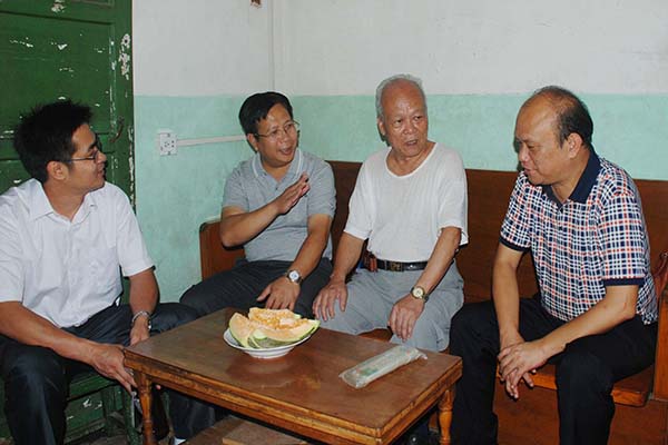 覃卫国副校长在老同志家中与老同志亲切交谈