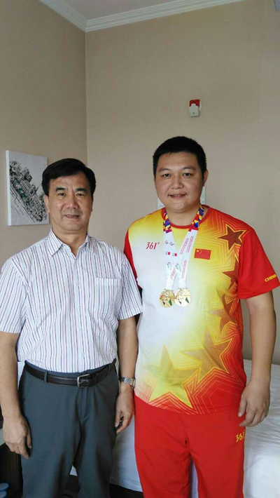 我校体育学院2000级体育教育专业吴国山校友（右）与桂林市残疾人联合会理事长李何（左）合影