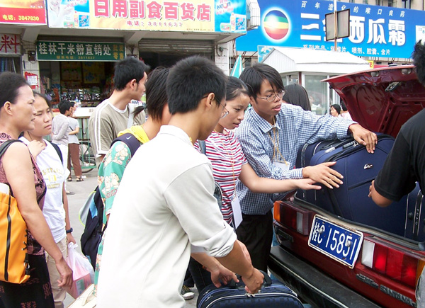 我校大学生志愿者在接待点帮新生运送行李。