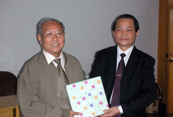 蓝常周副校长与新加坡乐龄义工协会华文分会会长互赠礼物。